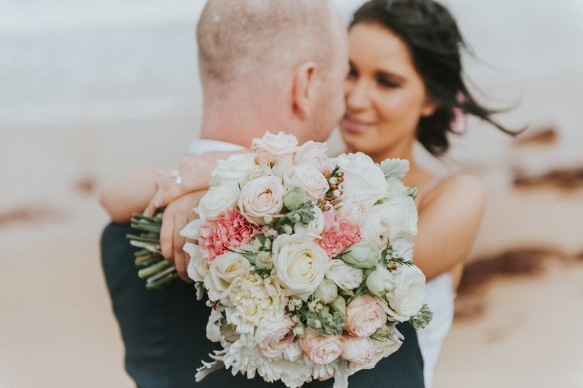 bride holding pink and green bouquet